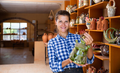 Wall Mural - Positive female artisan having ceramics in workshop. High quality photo