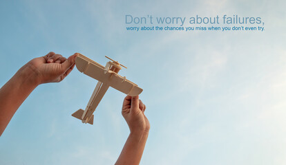 Motivational quotes, Happy kid playing with toy wooden airplane against sunset sky background.