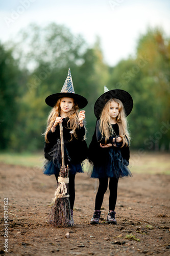 two girls dressed as witches in the park during halloween