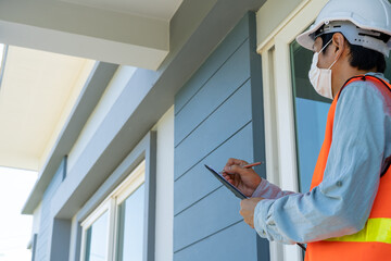 Engineers or inspectors in orange reflective vests are taking notes and checking with clipboards at the building's construction site, contractor inspections and engineering concepts.