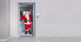 Fototapeta  - Man disguised as Santa Claus, inside an elevator in a building at Christmas