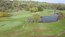Aerial View Of Golf Course With A Rich Green Turf, Putting Green, Sand Bunker And Water Hazards.