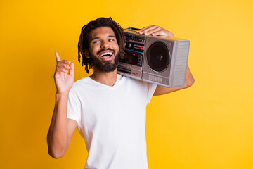 Wall Mural - Young black guy raise finger up look empty space hold vintage recorder open mouth wear white t-shirt isolated yellow color background