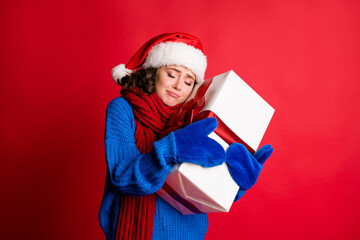 Poster - Portrait of her she nice attractive pretty lovely candid dreamy girl wearing festal cloth holding in hands embracing big giftbox St Nicholas isolated bright vivid shine vibrant red color background