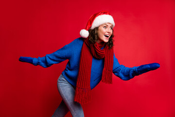 Poster - Portrait of her she nice attractive pretty glad cheerful cheery girl wearing Santa hat having fun skiing rolling skates pastime free time isolated bright vivid shine vibrant red color background