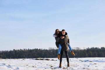 Wall Mural - happy couple hugging and laughing outdoors in winter.