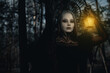 Portrait of woman in image of witch with glowing lamp in her hand in forest.