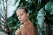 © luengo_ua - Close up outdoor portrait of young beautiful woman against green tropical leaves.