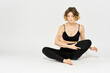 © SHOTPRIME STUDIO - Woman in leggings meditate in a light room with her legs crossed yoga asana