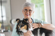 © goodluz - Cheerful veterinarian woman with dog