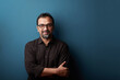 © AJay - Portrait of a happy middle aged man against a blue wall background.