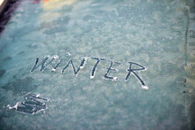 Written Text Winter On A Frost Car Windshield. Morning Shot
