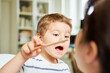 Kind untersucht spielerisch Kinderärztin mit Spatel