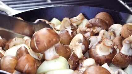 Wall Mural - Grilling organic mushrooms and onions in cast iron frying pan over the gas burning grill.