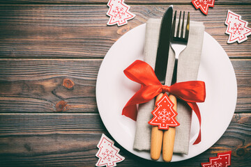 Sticker - Top view of plate, fork and knife served on Christmas decorated wooden background. New Year Eve concept with copy space