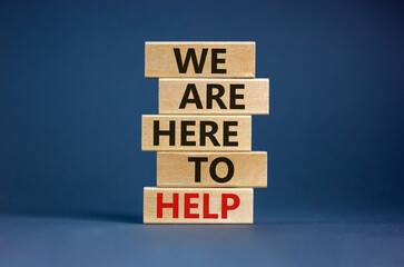 Wall Mural - Wooden blocks with text 'we are here to help'. Beautiful grey background, copy space. Business concept.