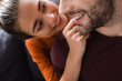 © LIGHTFIELD STUDIOS - smiling woman touching face of happy man on blurred background
