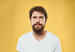 © SHOTPRIME STUDIO - A man with a beard and mustache on a yellow background and a white T-shirt