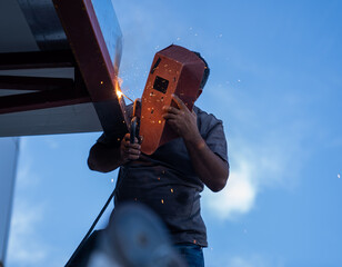 Welder man is doing his magic. Welder mask and industrial work