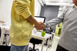 © Svitlana - Cropped shot of cheerful aged man, senior intern shaking hands with young male colleague at his new job in the modern office