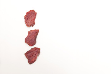 Wall Mural - Three pieces of beef tenderloin on a light background with copy space. Top view