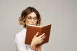 © SHOTPRIME STUDIO - woman with notepad in hands business work beige background glasses hairstyle