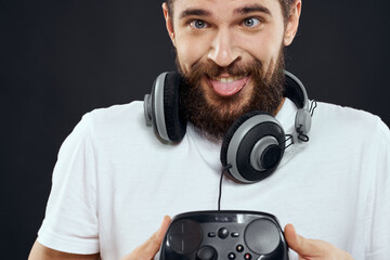 Wall Mural - Man with joystick in hands headphones technology leisure game lifestyle dark isolated background