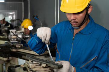 Male factory mechanic expert repair a production machine using wrench tools in factory maintenance office with protective glasses, gloves and helmet in factory uniform