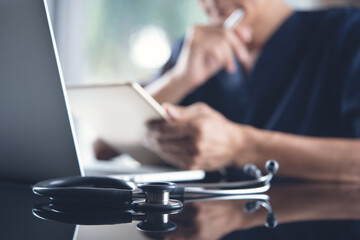 Wall Mural - Doctor reviewing medical report during working on laptop computer in medical office