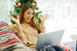© chinnarach - close up young asian woman using internet to video call with friends and family at home to greeting and celebration in merry christmas and happy new year season for holiday lifestyle concept