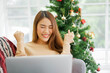 © chinnarach - close up young asian woman feeling happy and raised hand during using laptop after get discount promotion on marketplace website (online shopping) in black friday and cyber Monday of christmas festiva