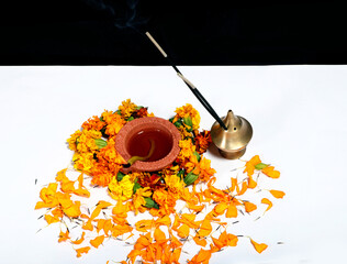 Canvas Print - Marigold flowers around Clay Oil Lamp or Diwali Diya, over white background. selective focus