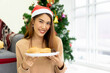 © chinnarach - close up young asian woman holding dish of bread (brunch meal) to show in living room for chrsitmas celebration and holiday lifestyle concept