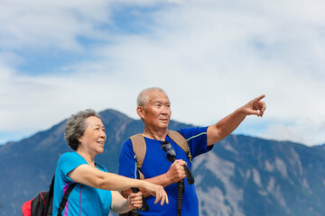 happy asian senior couple hiking in nature