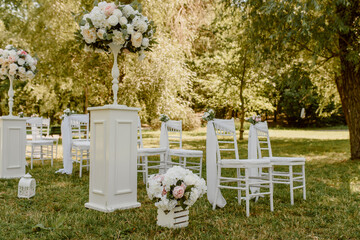 Wall Mural - Wedding ceremony outdoors in the park. White chairs decorated with roses.