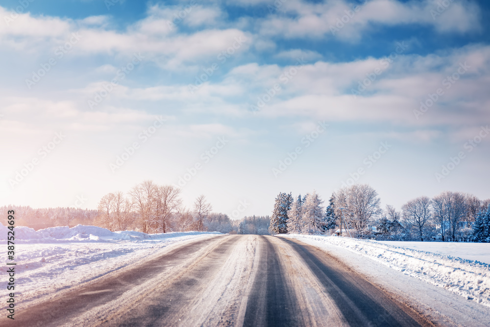 Winter road with snow and trees all around - obrazy, fototapety, plakaty 