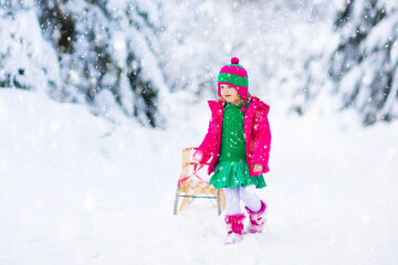 Wall Mural - Girl on sled ride. Child sledding. Kid on sledge