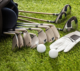 Wall Mural - Golf equipment on green grass golf course, close up view.