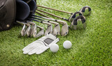 Golf equipment on green grass golf course, close up view.