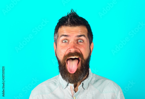 Bearded man shows tongue. People emotions. Face expression. Fanny man. Happy man. Bearded man with long tongue. Feeling and emotions. Isolated.