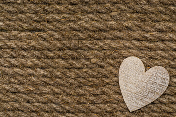 Wooden heart on a jute textured background. Festive background. Valentine's Day