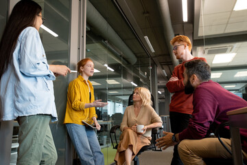 Poster - Group of intercultural colleagues in casualwear listening to young businesswoman