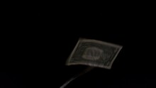 A One Dollar Banknotes Fluttering On A Black Background. A Dollar Bills Flies In The Wind.