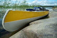 Three-seater Kayak With Oars Is Parked By The Rocky Shore, Against The Backdrop Of A Beautiful Landscape. Active Rest.