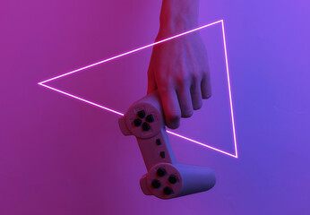 Wall Mural - Gamer concept. Hand holds gamepad. Creative pop art pink blue neon color. Trendy gradient illumination. Night light