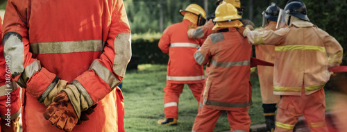 Fotomural Firefighter using extinguisher or Twirl water fog type fire extinguisher to spray water from hose for fire fighting with fire flame on fuel