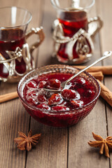 Wall Mural - Cherry jam in a glass bowl on wooden background