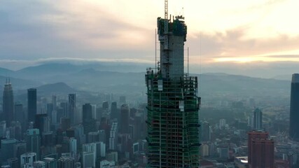 Wall Mural - Establishing aerial cinematic drone b-roll shot of sunrise at Kuala Lumpur city skyline. 