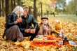 Family at picnic in the park.hot cocoa, croissants, yellow dry flowers. leaf fall, lifestyle.
