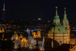  The tower of the Church of St. Nicholas is a Baroque church located in Prague from 1625 in the center of Prague. in the background a view of street lights in the city at night